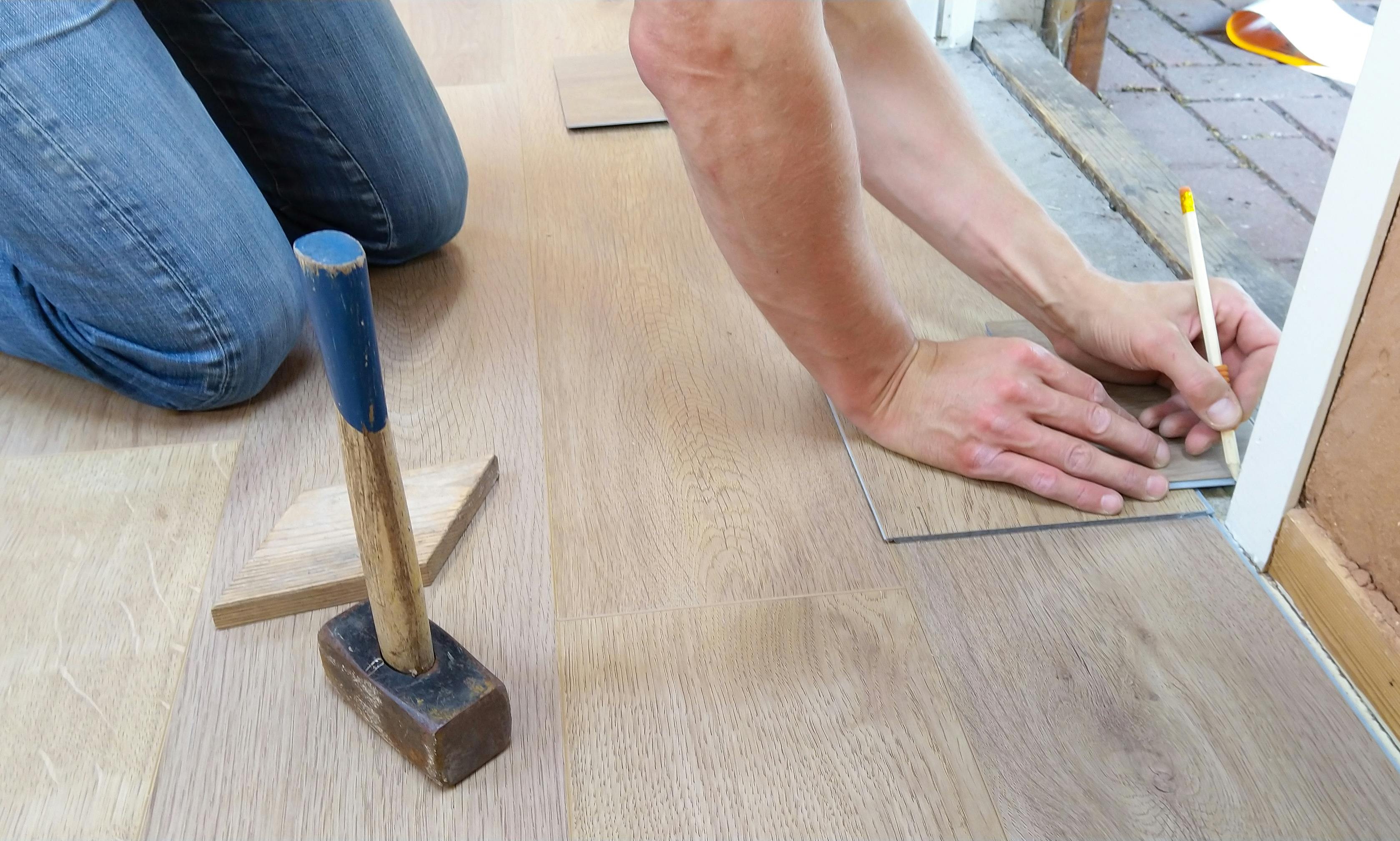 Crew installing luxury vinyl plank with proper spacing